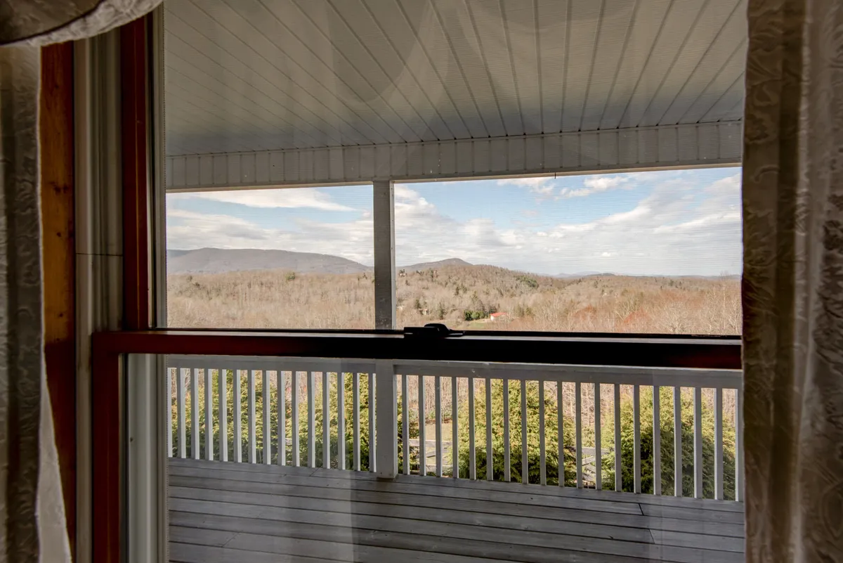 A beautiful mountain landscape viewed from a spacious balcony, with a clear sky and a sense of calm. The balcony is positioned for stargazing, enjoying sunrises, or simply unwinding with a book while appreciating the vista.